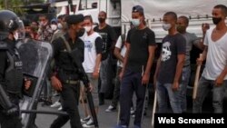 Jóvenes armados con garrotes obligados bajo amenazas a enfrentarse a los manifestantes en Cuba.
