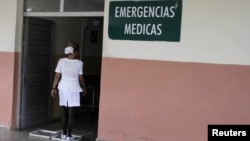 Enfermera cubana se desinfecta los zapatas a la entrada de un hospital en La Habana, Cuba.