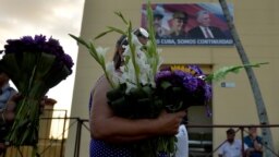 Una mujer lleva flores a San Lázaro en El Rincón, La Habana (Foto: Yamil Lage/AFP).