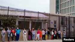 Cubanos hacen fila para entrar a la Embajada de EEUU en La Habana.