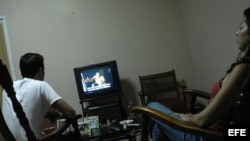 Una pareja cubana observa en su televisor la serie estadounidense "Los Soprano", trasmitida por la Televisión Nacional.