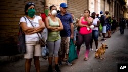Cubanos hacen fila para comprar alimentos.