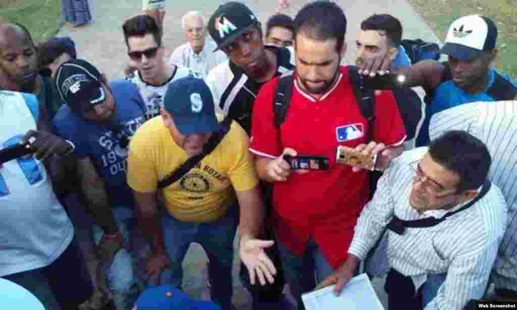 Integrantes de la Peña Deportiva MLB, reunidos en el Parque John Lennon, en El Vedado, solicitan autógrafos a los peloteros de Grandes Ligas, Yonder Alonso y Danny Valencia.