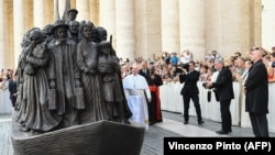 Papa Francisco ante una escultura de Timothy P. Schmaltz que refleja a un grupo de 140 migrantes de diferentes tiempos y culturas.