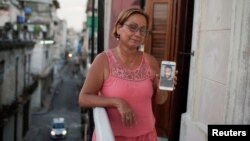 Raisa González reacciona mientras muestra una foto de su hijo Anyelo Troya González, un artista sancionado tras protestas, en La Habana, Cuba, el 20 de julio de 2021. Fotografía tomada el 20 de julio de 2021. REUTERS / Alexandre Meneghini