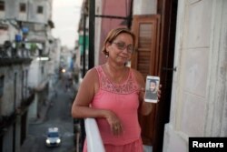 Raisa González reacciona mientras muestra una foto de su hijo Angelo Troya González, un artista sancionado tras protestas, en La Habana, Cuba, el 20 de julio de 2021. Fotografía tomada el 20 de julio de 2021. REUTERS / Alexandre Meneghini