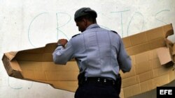 Fotografía de archivo de un policía cubano tapando mensajes antigubernamentales
