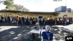 Venezolanos esperan en una cola por los alimentos distribuidos por el programa CLAP. AFP/ Matias Delacroix