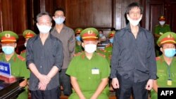 Nguyen Tuong Thuy (I), periodista independiente de Vietnam, y sus dos colegas durante el juicio, en enero 2021. (STR/VNA/AFP).