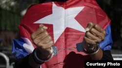 Activistas cubanos presentan fotos de presos políticos en la isla. (Foto: ProActivo Miami)