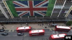 Peatones caminan por Oxford Street donde se ha colocado una bandera británica en la fachada de unos grnades almacenes en Londres (Reino Unido) durante la jornada de referéndum por el "Brexit" hoy, 23 de junio de 2016.