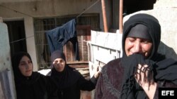 En la foto una mujer llora a la entrada de su casa en Bagdad, el pueblo iraquí ha sido duramente castigado por los conflctos armados.