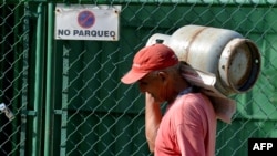 Un hombre carga una balita de gas en La Habana. AFP/ YAMIL LAGE