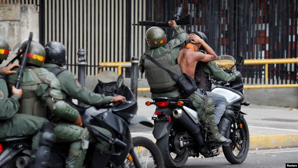 Guardia nacional conduce a uno de los detenidos en las protestas contra Nicolás Maduro el 23 de enero de 2019.