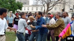 En esta foto de archivo, turbas del régimen cubano reprimen a varios disidentes, entre ellos Darsi Ferrer (cen) y su esposa cuando intentaron hacer una marcha por el Día de los Derechos Humanos en 10 de diciembre del 2006.