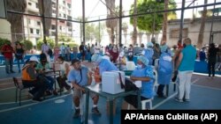 Trabajadores de la salud colocan dosis de la vacuna Sputnik V COVID-19 en el barrio 23 de Enero en Caracas, Venezuela, el 9 de junio de 2021. Foto: AP/Ariana Cubillos.