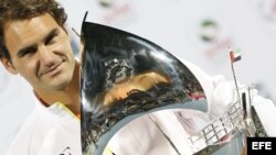 Federer sostiene el trofeo que le entregaron tras ganar por séptima vez el torneo de tenis de Dubai.