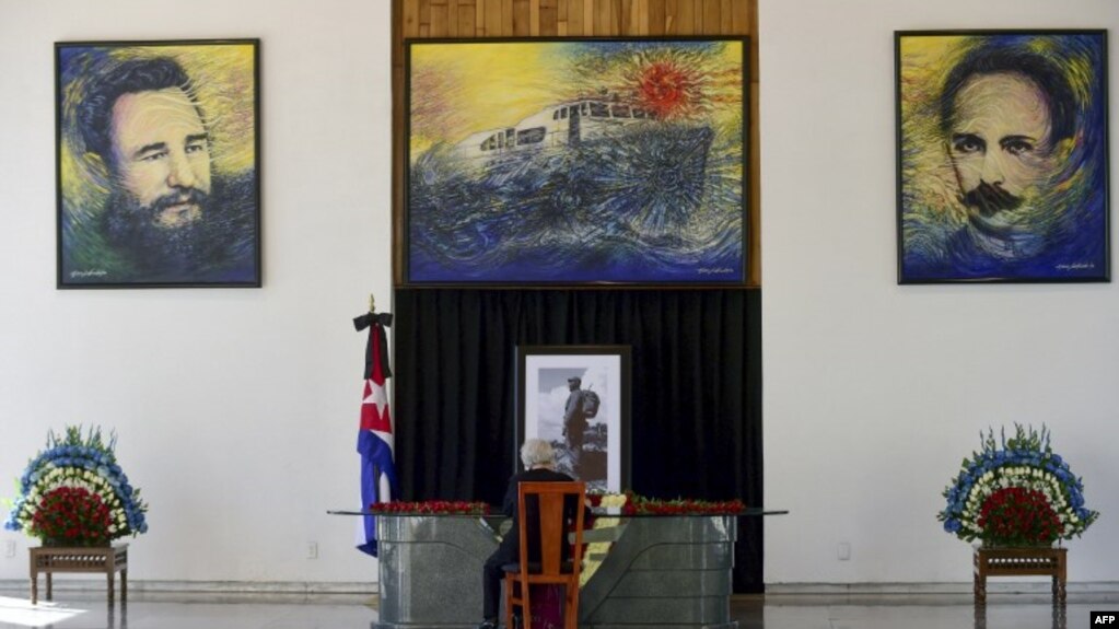 Una mujer firma un libro en la embajada de Cuba en Ciudad México en 2016, por la muerte del dictador Fidel Castro.