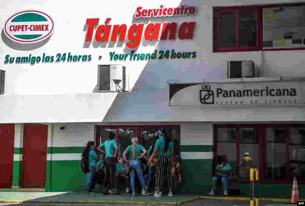 Empleados de una tienda de la Cadena Panamericana en La Habana hablan el jueves frente al establecimiento (Yamil Lage/AFP).
