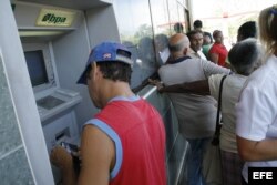 Un hombre extrae dinero de un cajero automático en un banco de La Habana.