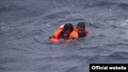 Dos personas se aferran a un dispositivo de flotación personal aproximadamente a 32 millas al sureste de Key West, Florida, el 7 de julio de 2021. 