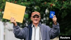 Foto Archivo. El cubano Pedro Ravelo muestra su pasaporte luego de recibir la visa de EEUU en la Embajada de EEUU en Bogotá el 22 de febrero de 2018. REUTERS/Jaime Saldarriaga 