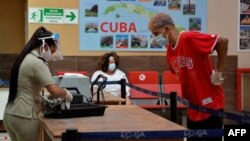 Las pertenencias de un pasajero son chequeadas por oficiales de Aduana en el Aeropuerto Internacional José Martí, en La Habana. (YAMIL LAGE / AFP)