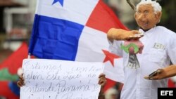 Un grupo de partidarios políticos y de la sociedad civil realizan una marcha con pancartas y muñecos en Panamá.