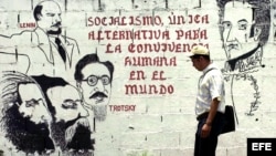 Un hombre pasa frente a un mural en apoyo al socialismo.