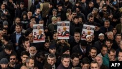 Manifestantes sostienen carteles con la imagen de Jamal Khashoggi en un funeral simbólico por el periodista asesinado.