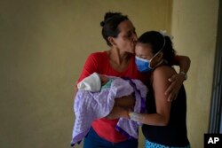 Nélida López besa a su hija, la madre primeriza Ada Mendoza,