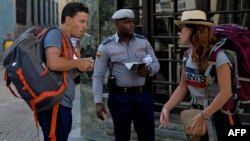 Un policía guía a turistas en una calle de La Habana en medio de la pandemia de coronavirus.
