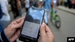 Una mujer chequea las opciones para conectarse a Internet en Cuba. (YAMIL LAGE / AFP)