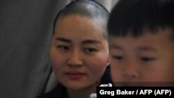 Esposa e hijo de Wang Quanzhang (Greg Baker / AFP)