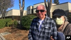 Eugenia Kendall usa una máscara junto a su esposo Iván frente a la Alcaldía de Vacaville, en California, el 27 de febrero del 2020.