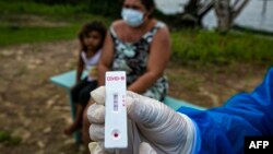 Una trabajadora sanitaria del gobierno muestra el resultado de una prueba de COVID-19 tomada el lunes en la isla de Marajó, en el estado de Pará (Tarso Sarraf/AFP).
