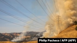 Líneas eléctricas amenazadas fue las llamas en California, 26 de octubre de 2019.