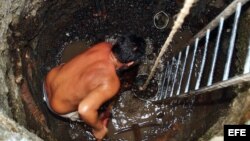 Un hombre cava un pozo en el patio de su casa en el barrio Alcides Pino, en la oriental provincia de Holguín.