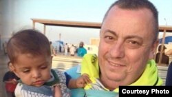 Alan Henning con un niño refugiado en Siria.