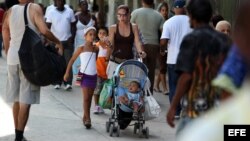 Una mujer camina con sus hijos por una céntrica calle de La Habana (Cuba).