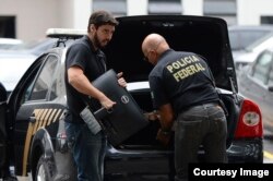 Agentes federales descargan en la sede de la policía en Río de Janeiro pruebas recogidas durante operación Lava Jato. (Tania Rego/Agencia Brasil)