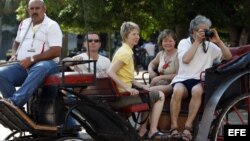 Un grupo de turistas pasea en coche por una calle de La Habana.