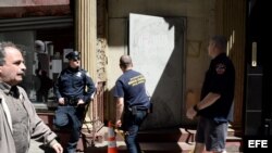 Un policía monta guardia mientras bomberos entran a un edificio en Park Place en el bajo Manhattan, donde una pieza de uno de los aviones destruidos en los ataques del 11 de septiembre fue descubierto en Nueva York (EE.UU.).