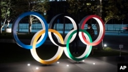 Los anillos olímpicos frente al nuevo Estadio Nacional de Tokio. 