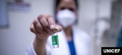 Una enfermera en Nueva Delhi muestra una ampolleta de la vacuna COVID-19