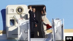 El presidente estadounidense, Barack Obama (i), y su esposa, Michelle Obama (d), suben al avión presidencial, en Air Force One, en el aeropuerto internacional de Ciudad del Cabo en Sudáfrica hoy, lunes 1 de julio de 2013. El presidente estadounidense, Bar