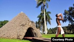 "Taíno" en la "aldea" Guamá soplando en un cobo o caracol (fotuto en lengua taína).