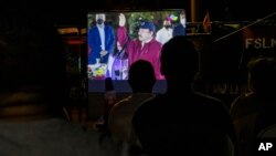Los vecinos ven la toma de posesión de Daniel Ortega en una pantalla gigante en un parque en el barrio Julio Buitrago de Managua. (AP Foto/Andrés Núñez)