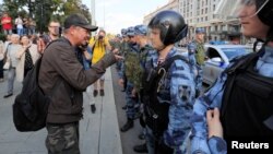 Un manifestante encara a la policía durante una protesta en Moscú para exigir a las autoridades que permitan a los candidatos de la oposición postularse en las elecciones locales.