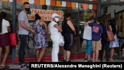 Cubanos hacen cola para comprar alimentos y otros productos en una tienda en La Habana. REUTERS/Alexandre Meneghini